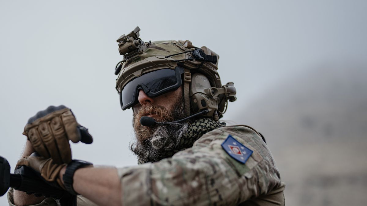 Operator wearing Ops-Core ballistic helmet with rails and comms integration