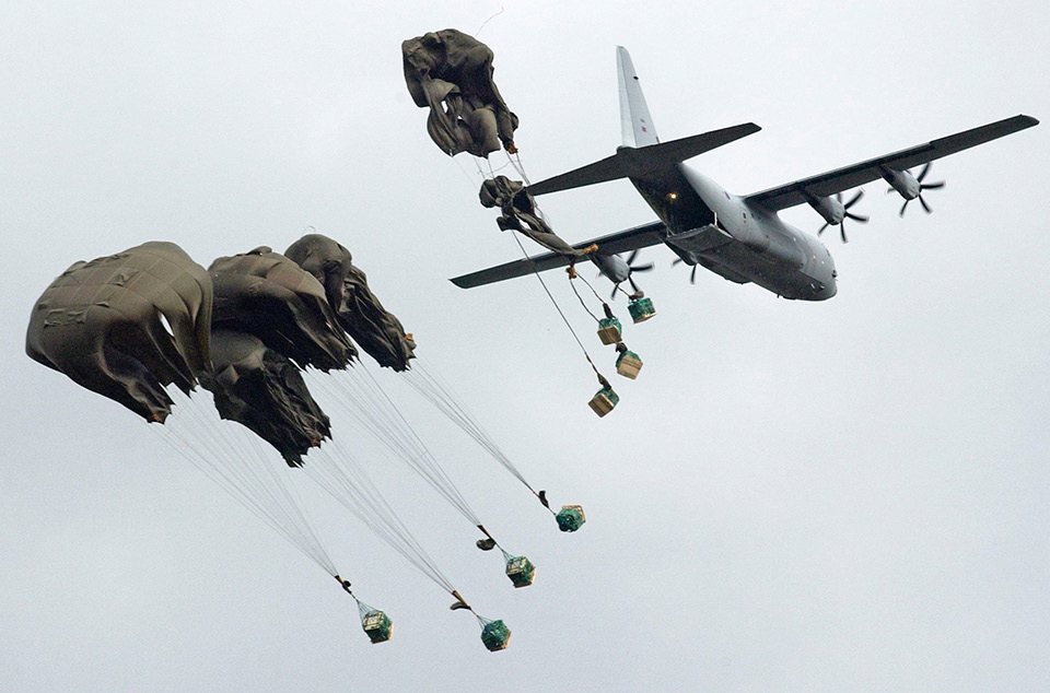 C-130 dropping clustered cruciform supply parachutes